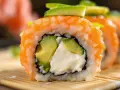 Rolka sushi z łososiem, awokado i kremowym serkiem. Idealny serek do sushi to taki, który jest kremowy i delikatny.
