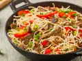 Makaron chow mein z wołowiną, papryką i szczypiorkiem w woku.