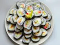 Talerz sushi z paluszkami krabowymi, awokado i łososiem. Idealne do nauki, jak przygotować paluszki krabowe do sushi.