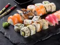 Różnorodne sushi: nigiri z łososiem, tuńczykiem i krewetką, rolki z węgorzem i awokado. Inspiracja do przepisów na sushi.