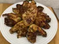 Chrupiące skrzydełka z airfryer ułożone na białym talerzu, apetycznie przypieczone i gotowe do podania.