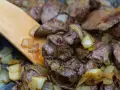 Smażona wątróbka z cebulką, mieszana drewnianą łopatką. Czy solic wątróbkę przed smażeniem? To pytanie, na które odpowiedź znajdziesz w kuchni.