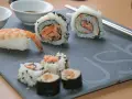 Jak przygotować krewetki do sushi? Na talerzu sushi z krewetką i rolkami z łososiem.