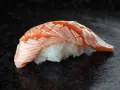 Jak wygląda sushi: delikatny ryż i soczysty, lekko opalony łosoś ułożony w wachlarz.