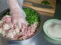 Mieszanie mielonego mięsa, kapusty i szczypiorku do pierożków gyoza. Przepis na pyszne domowe pierożki.