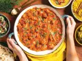 Pyszny **butter chicken przepis oryginalny** w kremowym sosie, podany z ryżem, sałatką i chlebkiem naan.