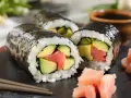 Trzy rolki maki sushi z łososiem i awokado, podane z imbirem i sosem sojowym. Pyszne maki sushi co to? To idealna przekąska!