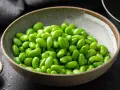 Miseczka pełna zielonej fasolki edamame, idealna do prostego przepisu.