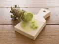Świeży korzeń wasabi jest tarty na drewnianej tarce. Czy wasabi jest zdrowe? Tak, ma właściwości antybakteryjne i przeciwzapalne.