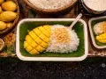 Pyszny mango sticky rice przepis: ryż z mleczkiem kokosowym, świeże mango i chrupiące prażone ziarna. Idealny deser.
