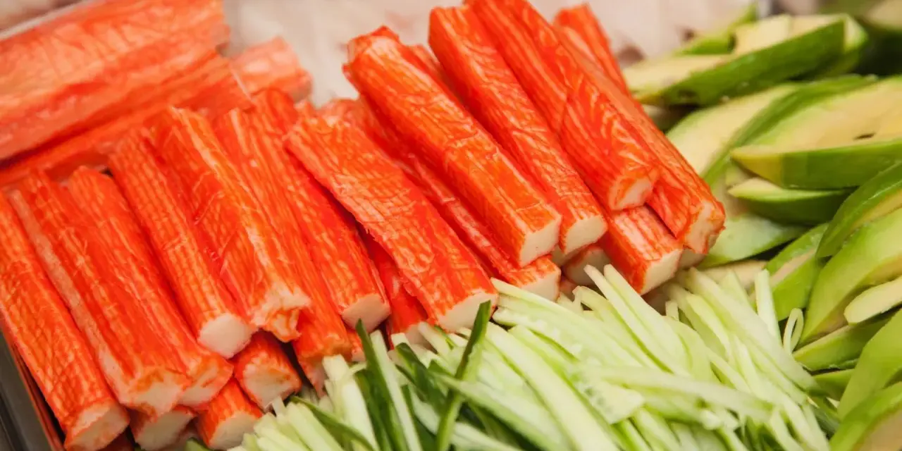 Paluszki surimi, pokrojony ogórek i awokado. Idealne składniki do sushi, które wyjaśniają, surimi co to jest.