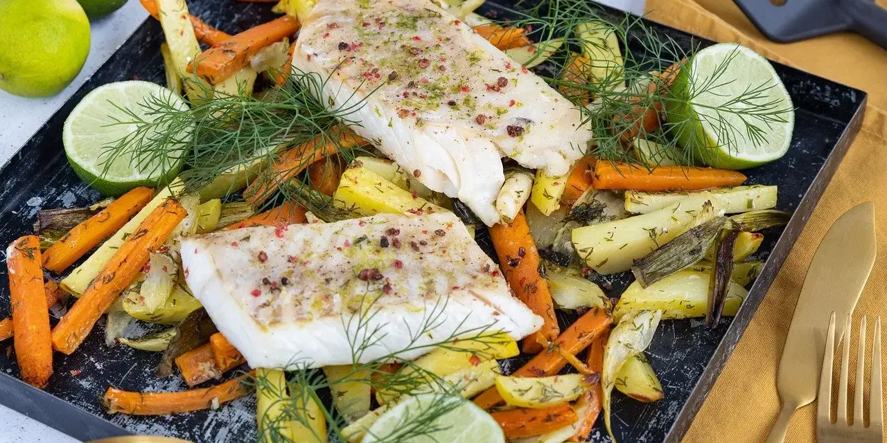 Pyszny filet z mintaja z piekarnika, podany z pieczonymi warzywami i limonką.