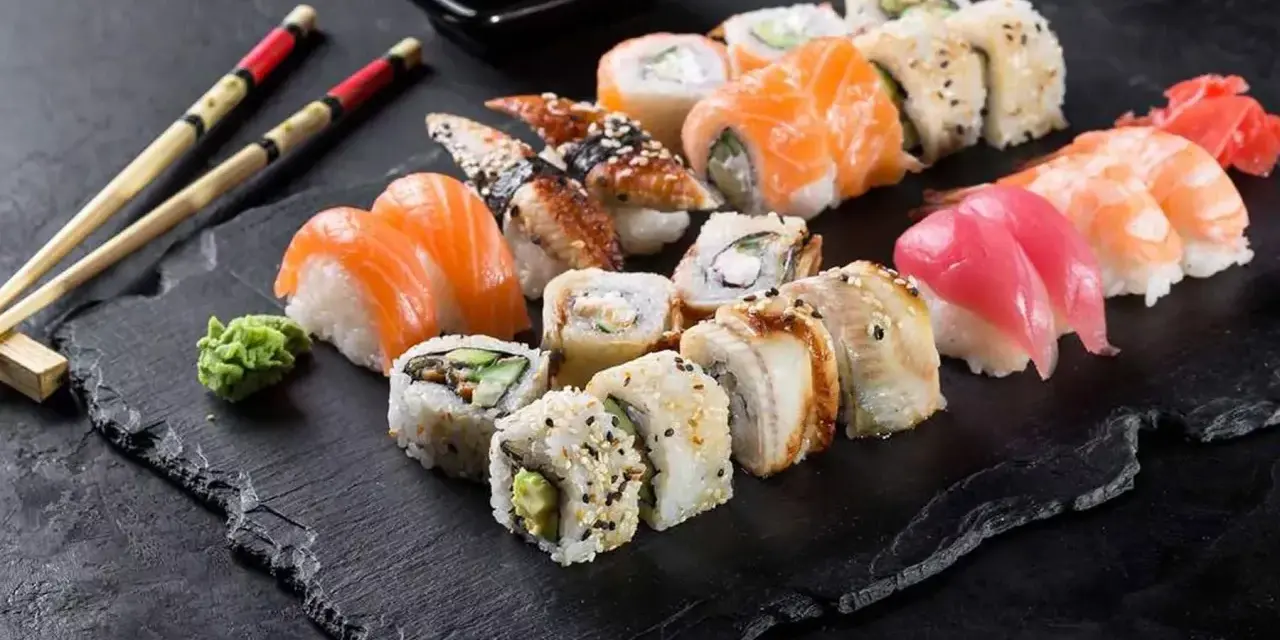 Różnorodne sushi: nigiri z łososiem, tuńczykiem i krewetką, rolki z węgorzem i awokado. Inspiracja do przepisów na sushi.