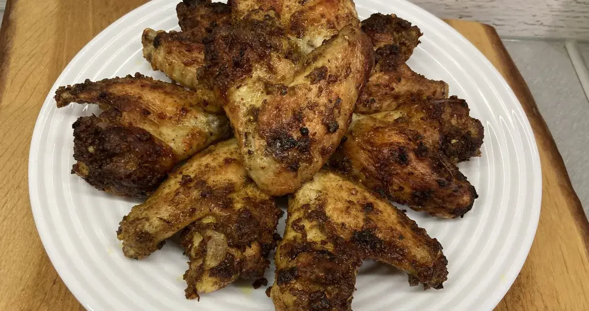 Chrupiące skrzydełka z airfryer ułożone na białym talerzu, apetycznie przypieczone i gotowe do podania.