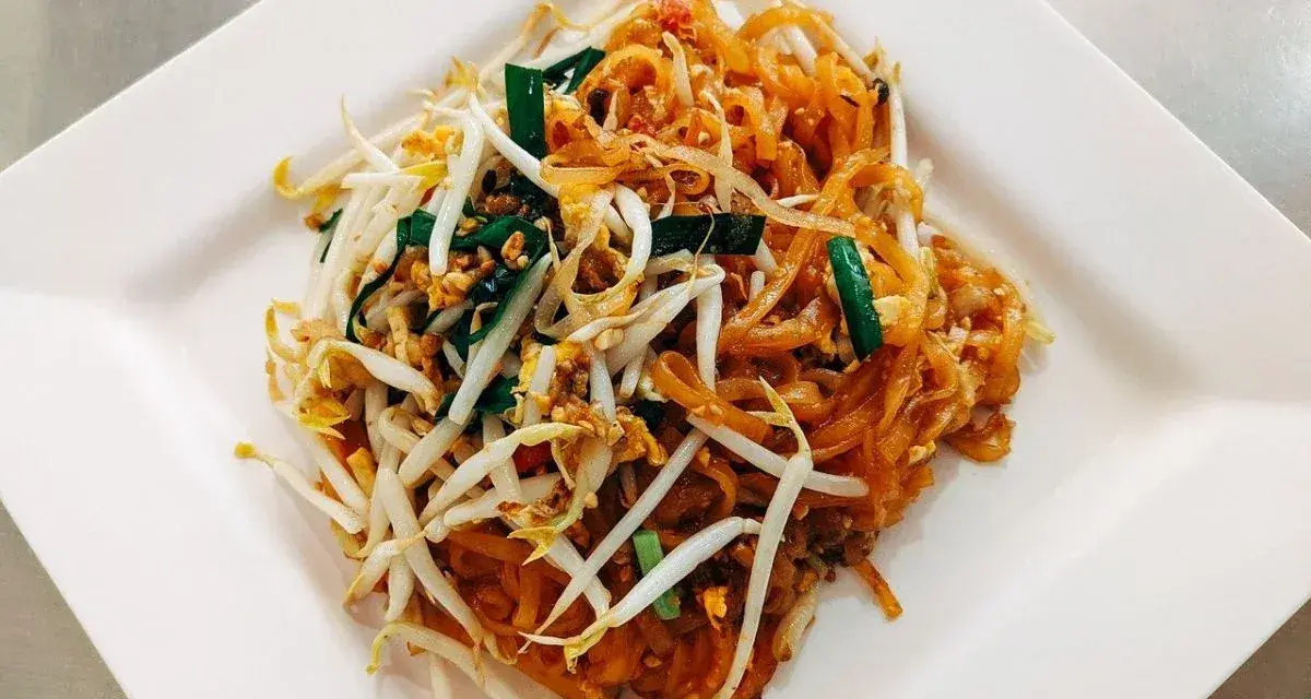 Pyszne danie Pad Thai z makaronem ryżowym, kiełkami fasoli mung, jajkiem i zieloną cebulką, polane charakterystycznym pad thai sosem.