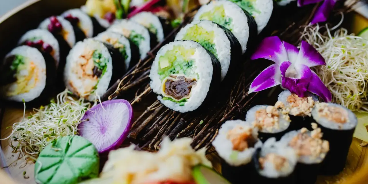 Piękne sushi z awokado i łososiem. Tradycyjne sushi nie zawiera glutenu, ale sos sojowy już tak.