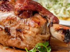 Soczysta, pieczona golonka na desce, idealna do podania. Dowiedz się, jak ugotować golonkę, żeby była miękka i rozpływała się w ustach.