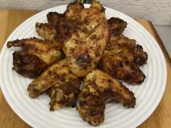 Chrupiące skrzydełka z airfryer ułożone na białym talerzu, apetycznie przypieczone i gotowe do podania.