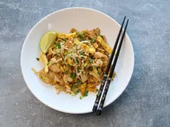 Pyszny pad thai oryginalny przepis z kurczakiem, jajkiem, orzeszkami i limonką.