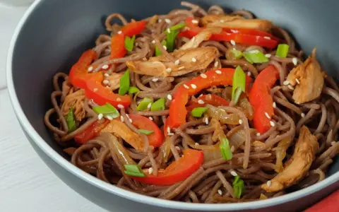 Makaron soba przepis: danie z makaronem gryczanym, kurczakiem, papryką i szczypiorkiem, posypane sezamem.