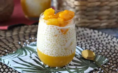 Pyszny deser z tapioki z mango, podany w szklance, z kawałkami owoców na wierzchu. Idealny na letnie popołudnie.