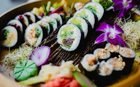Piękne sushi z awokado i łososiem. Tradycyjne sushi nie zawiera glutenu, ale sos sojowy już tak.