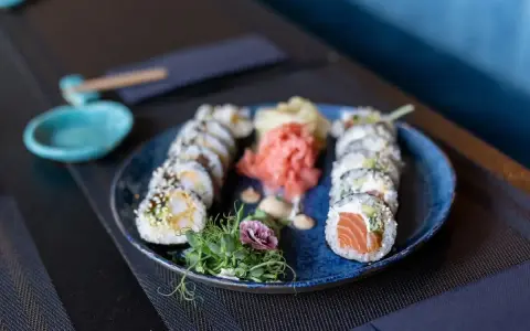 Talerz sushi z łososiem i krewetkami, marynowanym imbirem i wasabi. Czy sushi jest lekkostrawne? Tak, to zdrowa i lekka przekąska.