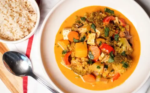 Pyszny, wegetariański massaman curry przepis z tofu, brokułami i marchewką. Podany z brązowym ryżem.