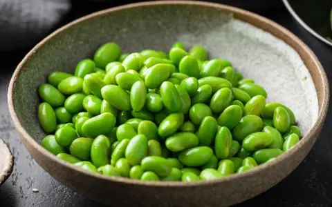Miseczka pełna zielonej fasolki edamame, idealna do prostego przepisu.