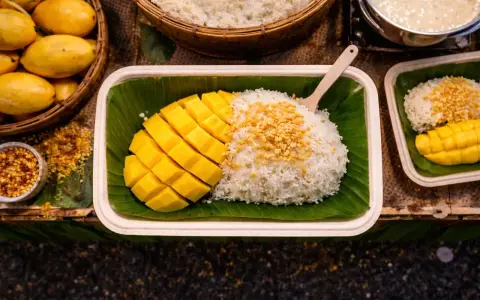Pyszny mango sticky rice przepis: ryż z mleczkiem kokosowym, świeże mango i chrupiące prażone ziarna. Idealny deser.