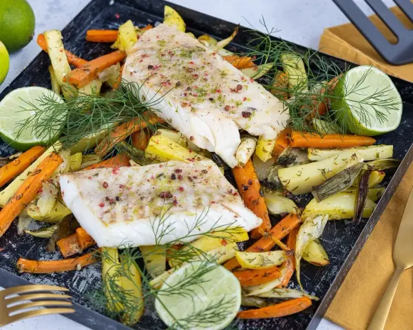 Pyszny filet z mintaja z piekarnika, podany z pieczonymi warzywami i limonką.