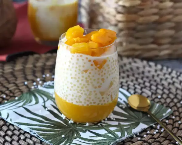 Pyszny deser z tapioki z mango, podany w szklance, z kawałkami owoców na wierzchu. Idealny na letnie popołudnie.