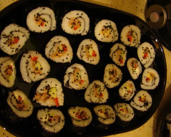 Roladki sushi z tuńczykiem, ogórkiem i papryką, posypane czarnym sezamem. Idealne, gdy zastanawiasz się, jak przygotować tuńczyka do sushi.
