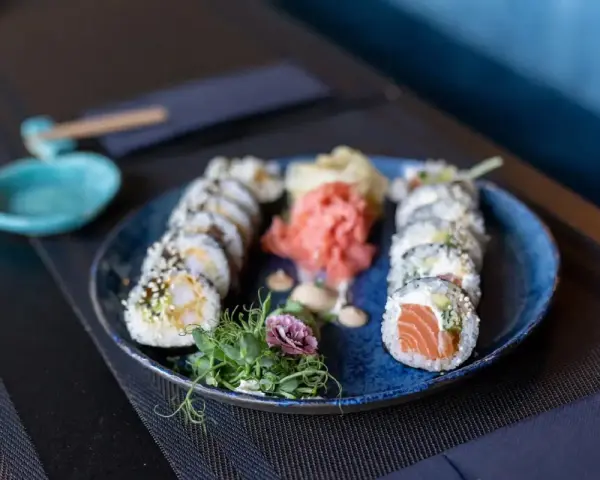 Talerz sushi z łososiem i krewetkami, marynowanym imbirem i wasabi. Czy sushi jest lekkostrawne? Tak, to zdrowa i lekka przekąska.