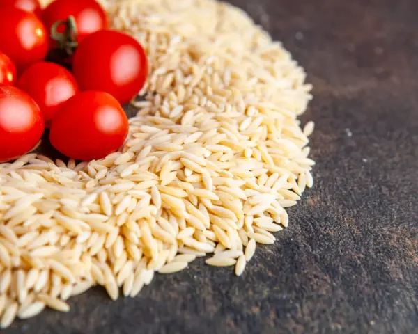 Czerwone pomidorki koktajlowe i makaron orzo. Ile gotować? Krótka odpowiedź: około 8-10 minut.