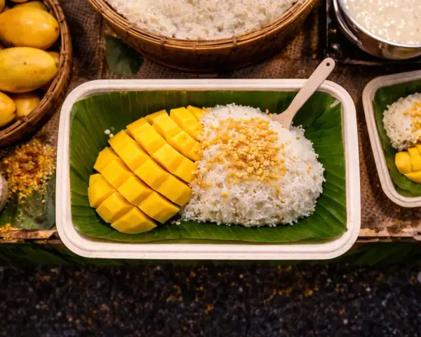 Pyszny mango sticky rice przepis: ryż z mleczkiem kokosowym, świeże mango i chrupiące prażone ziarna. Idealny deser.