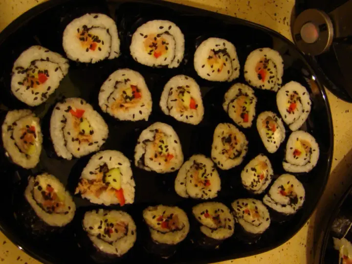 Roladki sushi z tuńczykiem, ogórkiem i papryką, posypane czarnym sezamem. Idealne, gdy zastanawiasz się, jak przygotować tuńczyka do sushi.