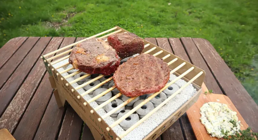Na grillu leżą soczyste steki i burger. Obok masło ziołowe, idealne do sosu kobe. Co to za pyszności!