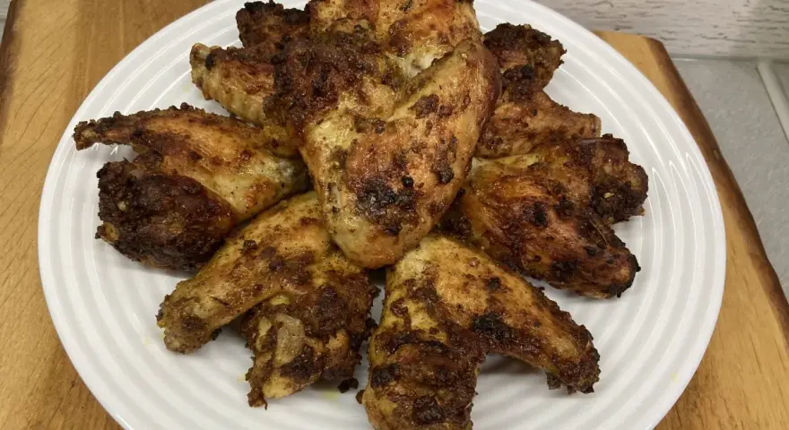 Chrupiące skrzydełka z airfryer ułożone na białym talerzu, apetycznie przypieczone i gotowe do podania.