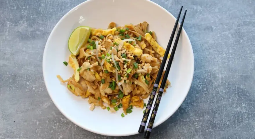 Pyszny pad thai oryginalny przepis z kurczakiem, jajkiem, orzeszkami i limonką.