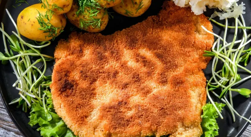 Chrupiący schabowy w panko, podany z młodymi ziemniaczkami, surówką i świeżą sałatą. Prawdziwa uczta dla podniebienia!