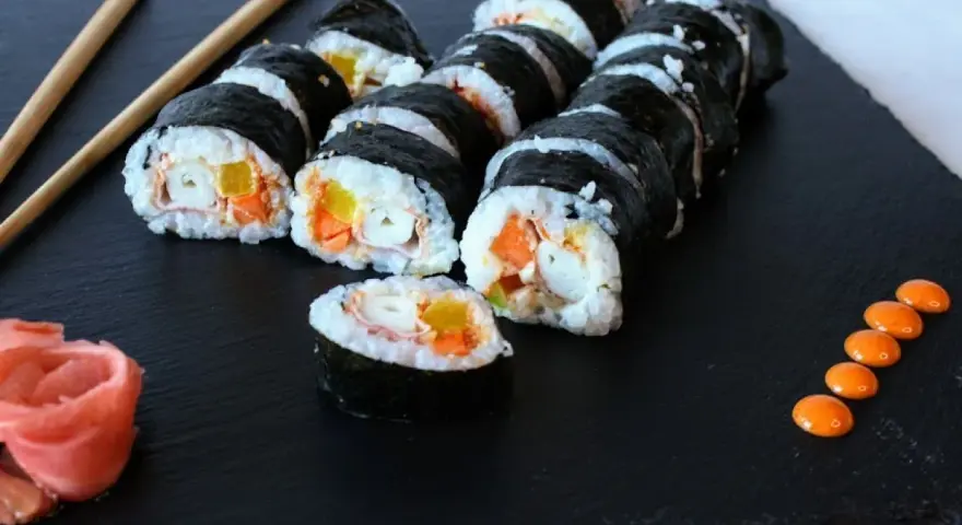 Roladki sushi z paluszkami surimi, marchewką i papryką. Prosty sposób, jak przygotować paluszki surimi do sushi.