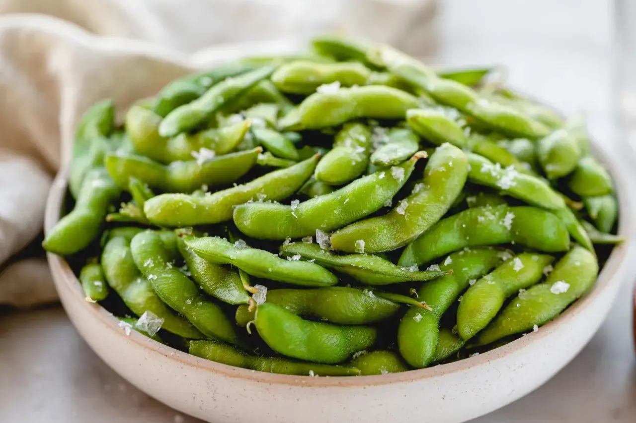 Miseczka pełna zielonej fasolki edamame posypanej solą. Idealna przekąska, gdy szukasz prostego przepisu na edamame.