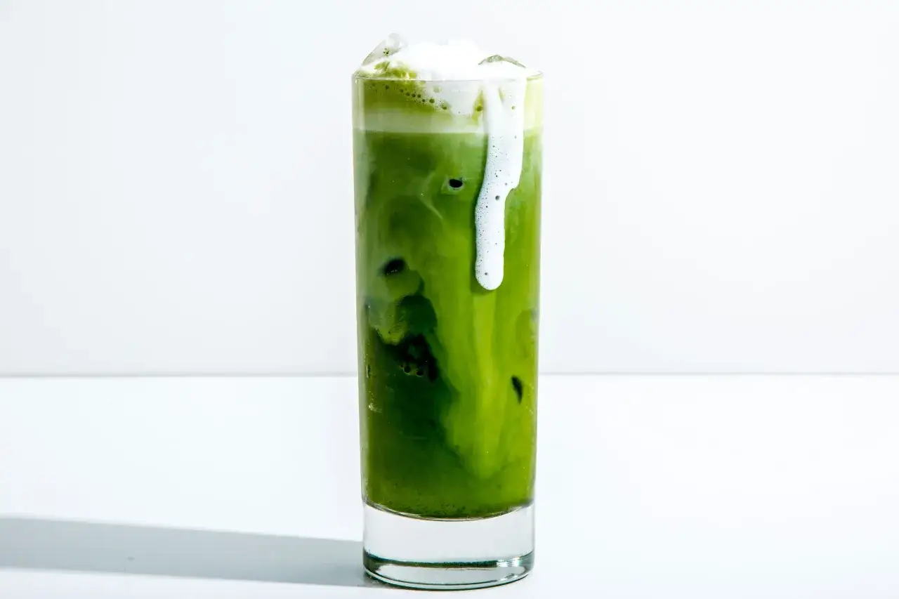 Orzeźwiający iced matcha latte z pianką i lodem, idealny na upalny dzień.