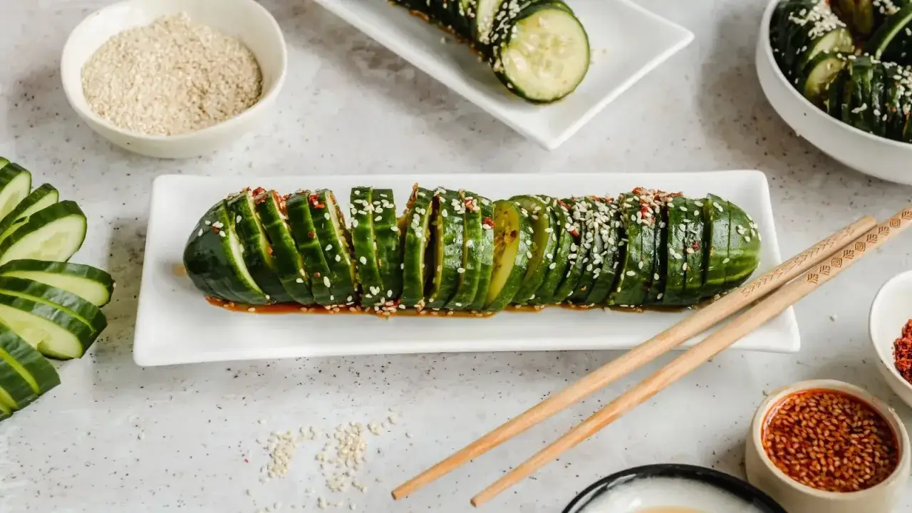 Pyszne ogórki po koreańsku, pokrojone w plastry i polane sosem z sezamem i chili. Idealna przekąska!
