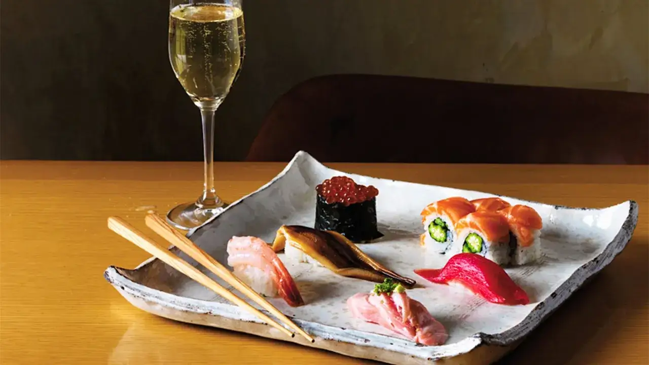 Wykwintne sushi z łososiem, krewetką, węgorzem i ikrą, podane z kieliszkiem szampana. Idealne na wieczór, gdy masz ochotę na coś pysznego do sushi.
