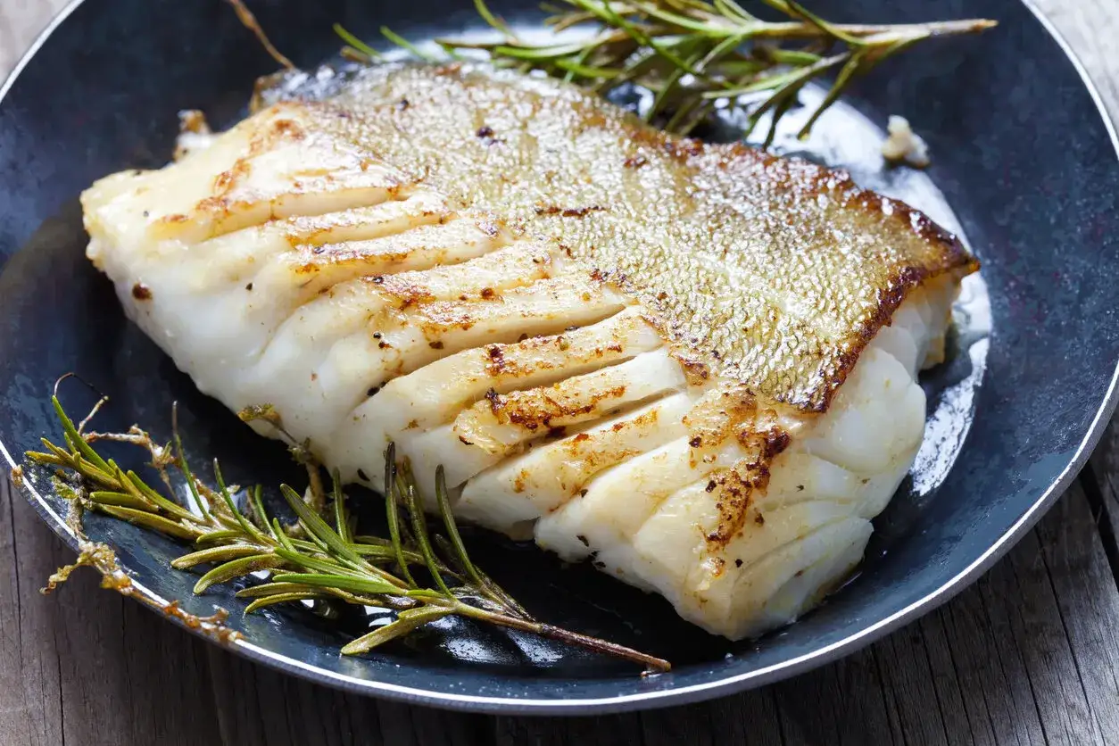 Smażony filet z dorsza z chrupiącą skórką, podany z rozmarynem. Idealny przepis na owoce morza.