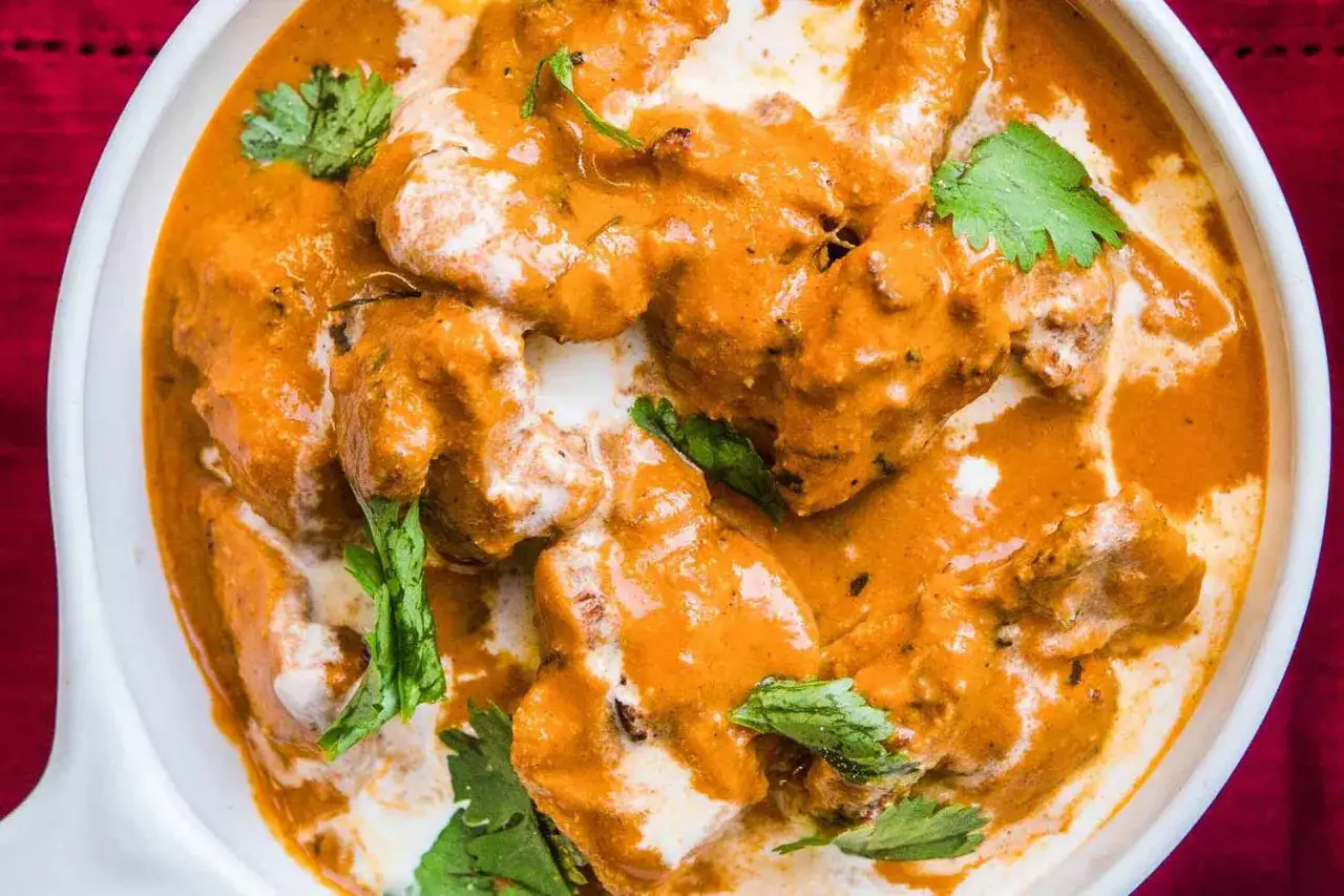 Aksamitny, kremowy sos otula kawałki kurczaka w daniu butter chicken przepis oryginalny. Udekorowane świeżą kolendrą.