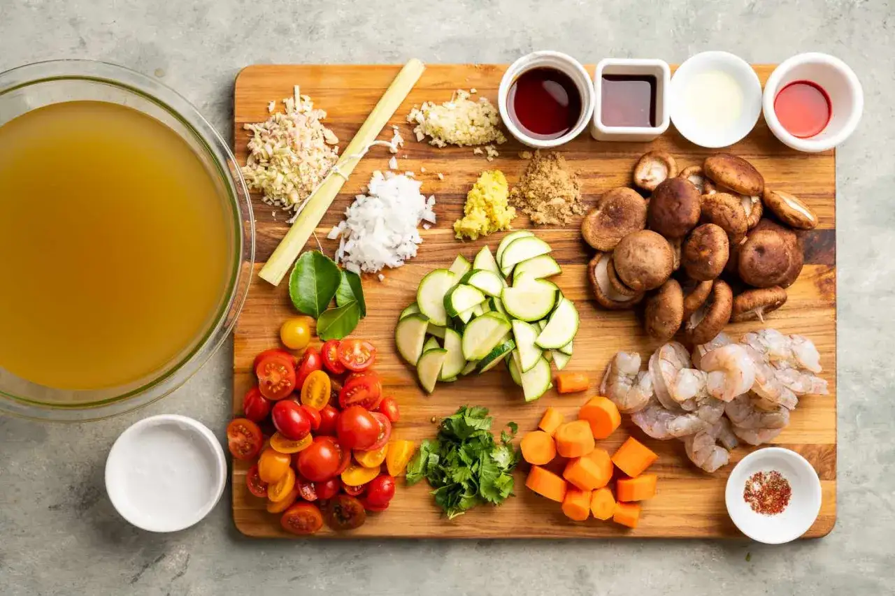 Składniki do zupy tom yum: bulion, krewetki, grzyby, cukinia, pomidorki, marchewka, trawa cytrynowa, czosnek, imbir, limonka, sos rybny, mleczko kokosowe.