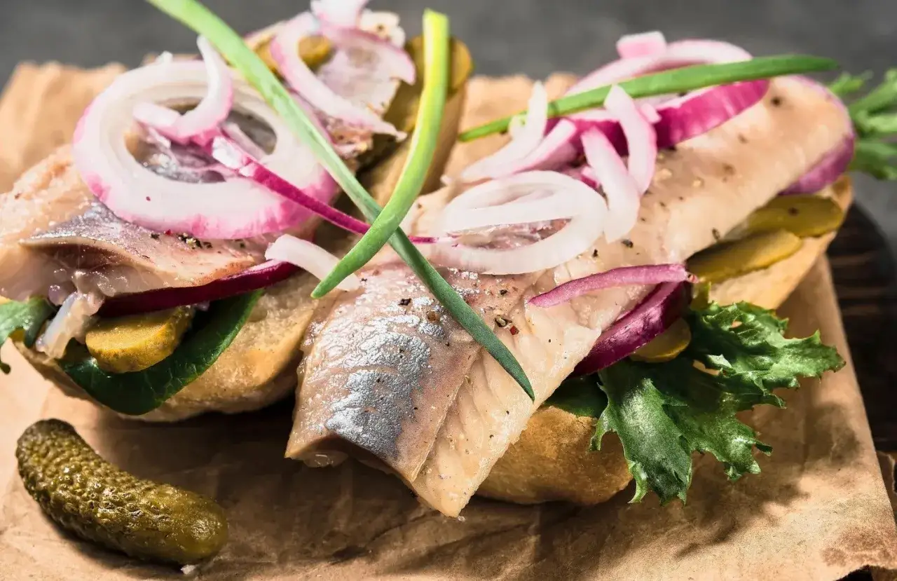 Kanapki ze śledziem, cebulą i ogórkiem. Czy śledź jest zdrowy? Tak, to bogactwo kwasów omega-3!